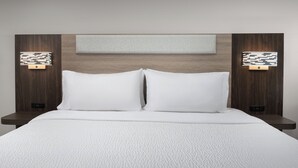 A modern hotel room with a large bed, two bedside tables, and a headboard with built-in lighting. - Holiday Inn Express Spokane Airport by IHG (Spokane)