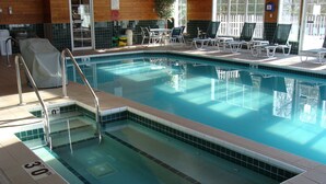 An indoor swimming pool with clear water, marked depth lines, and a tiled edge.