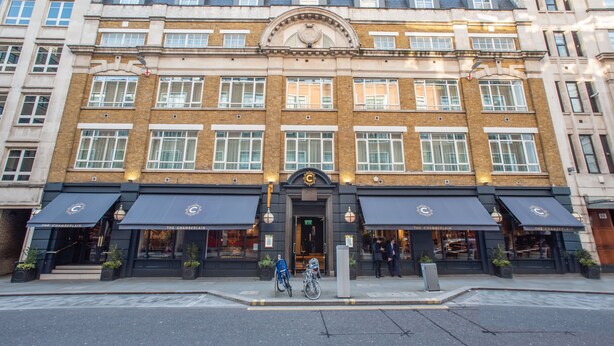 A multi-story building with a classic architectural style, featuring a central entrance with a clock above it. - The Chamberlain Hotel (London)