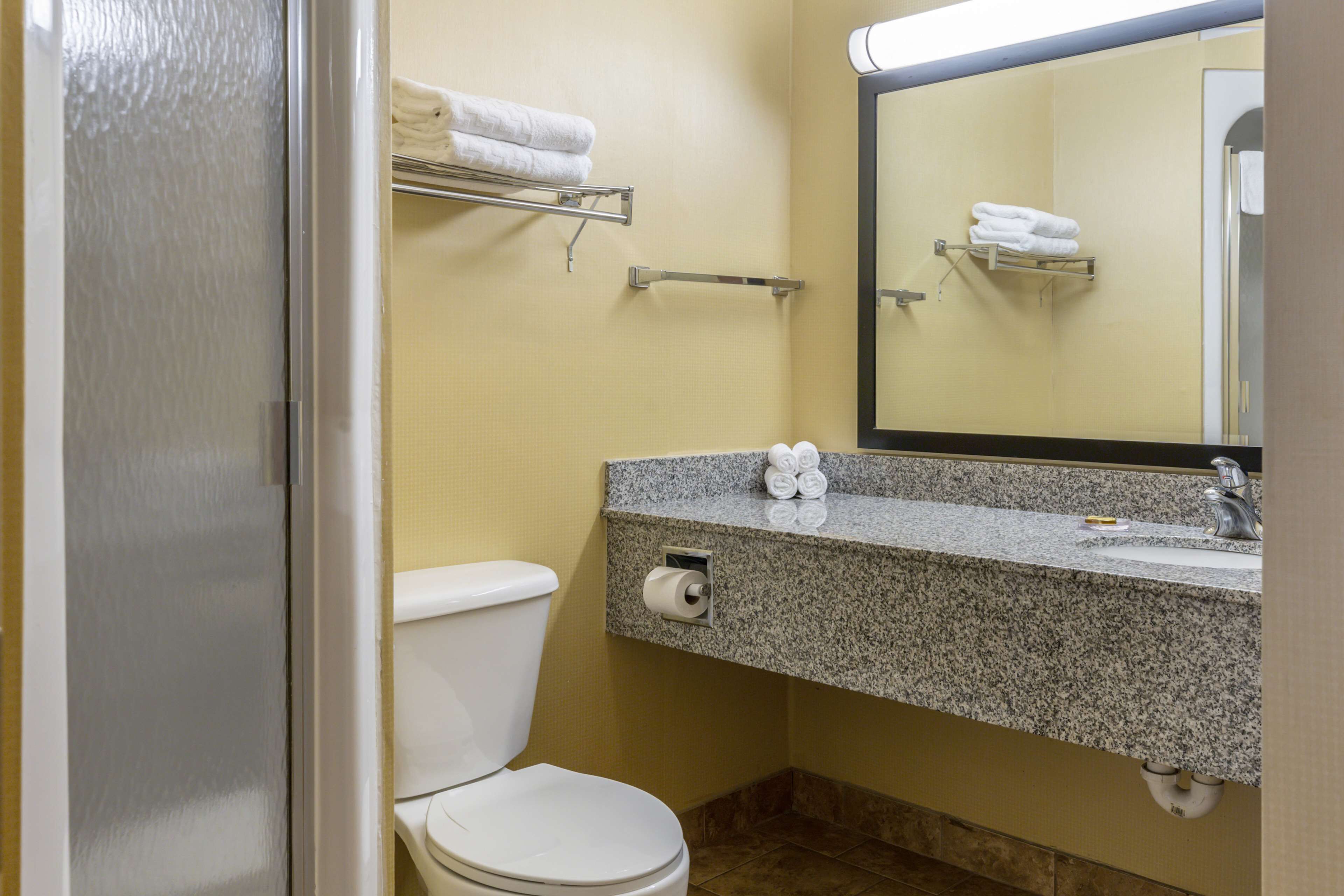 Une salle de bain équipée de toilettes, d’un lavabo et d’un porte-serviettes.
