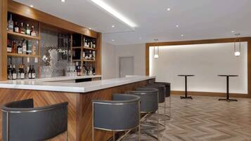 Un espace bar moderne, doté d’un comptoir en bois, de plusieurs tabourets et d’une variété de bouteilles et de verres.
