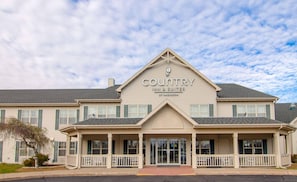A Country Inn & Suites building with a symmetrical facade, large windows, and a prominent entrance with a covered porch. - Country Inn & Suites by Radisson, Stockton, IL (Stockton)