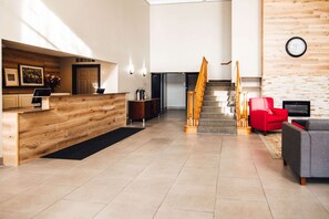 Welcome to our hotel lobby, featuring a reception desk, staircase, and cozy seating area.