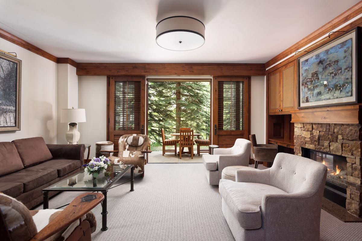 A living room with a fireplace, a sofa, a coffee table, and a dining area with a table and chairs.