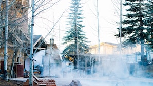 A pool area with a hot tub, stone steps, and a wooden bench. - Four Seasons Resort Jackson Hole (Teton Village)