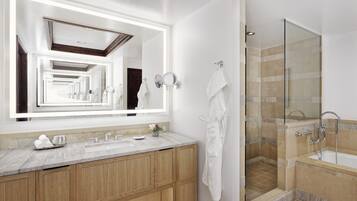 A modern bathroom with a large mirror, wooden vanity, and a glass-enclosed shower area.