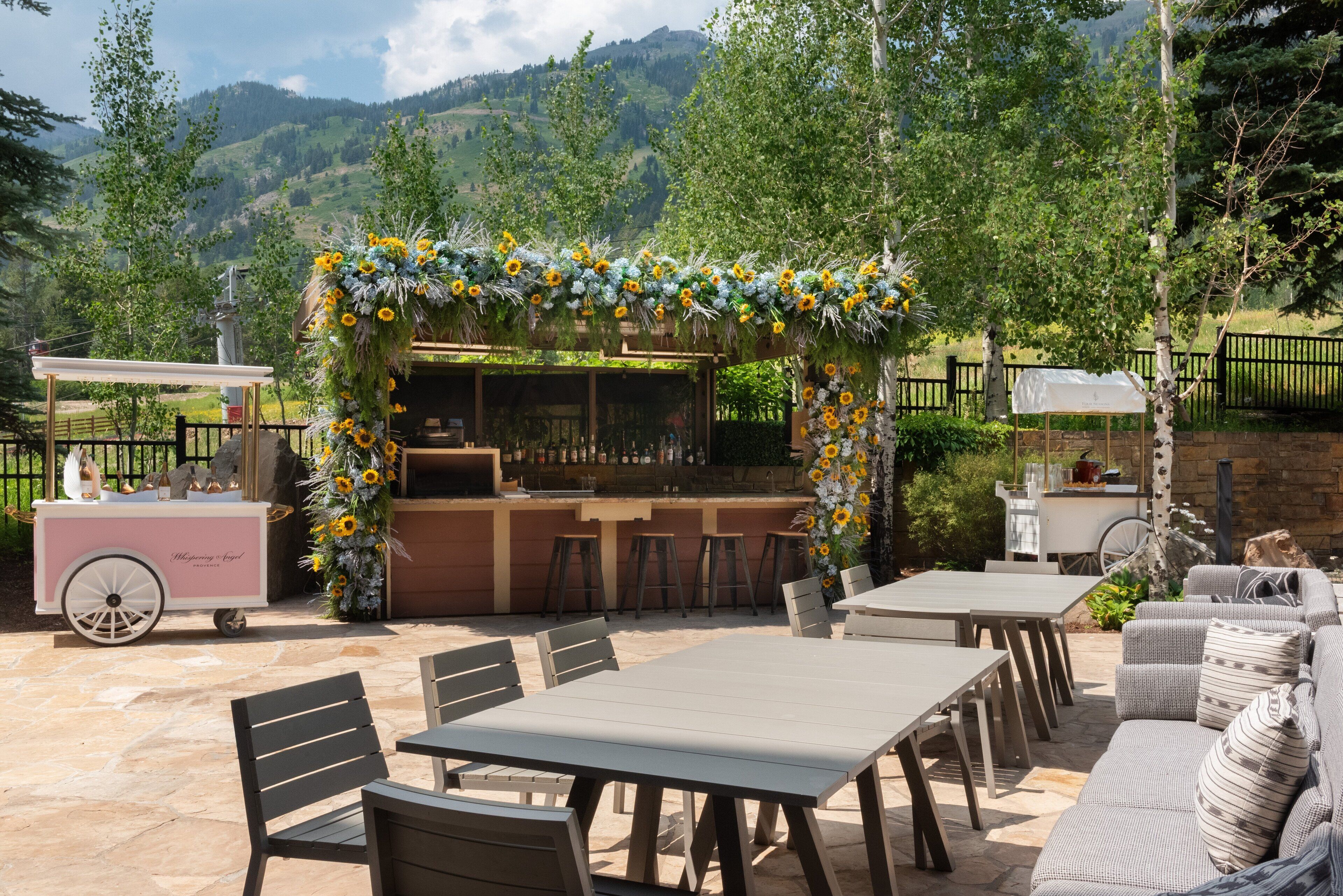 An outdoor patio with a bar area, seating, and a decorative archway.