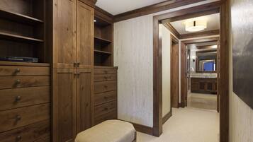 A hallway with wooden cabinets, a bench, and a view into a kitchen area.