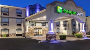 A Holiday Inn Express building with a stone facade, multiple balconies, and a well-lit entrance.