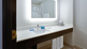 A modern bathroom with a white sink, a large mirror, and a towel rack. - Holiday Inn Express Hotel & Suites Dallas - Duncanville by IHG (Duncanville)
