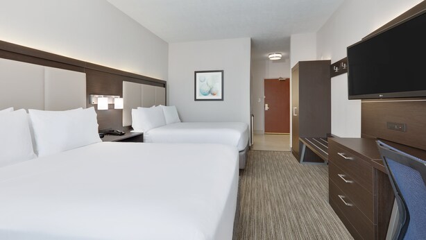 A hotel room with two beds, a desk, a television, and a door leading to a bathroom. - Holiday Inn Express Hotel & Suites Dallas - Duncanville by IHG (Duncanville)