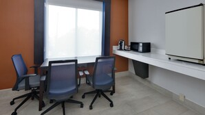 A conference room with a large table, four office chairs, a whiteboard, a coffee maker, and a television. - Holiday Inn Express Hotel & Suites Dallas - Duncanville by IHG (Duncanville)