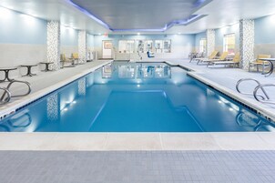 Una piscina techada, sillones reclinables de piscina