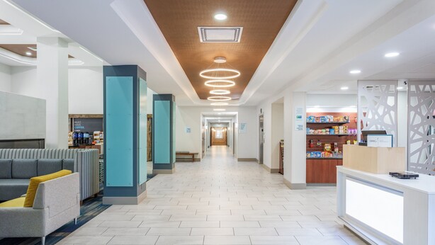 Hall d'hotel con reception, area relax e caffetteria.
