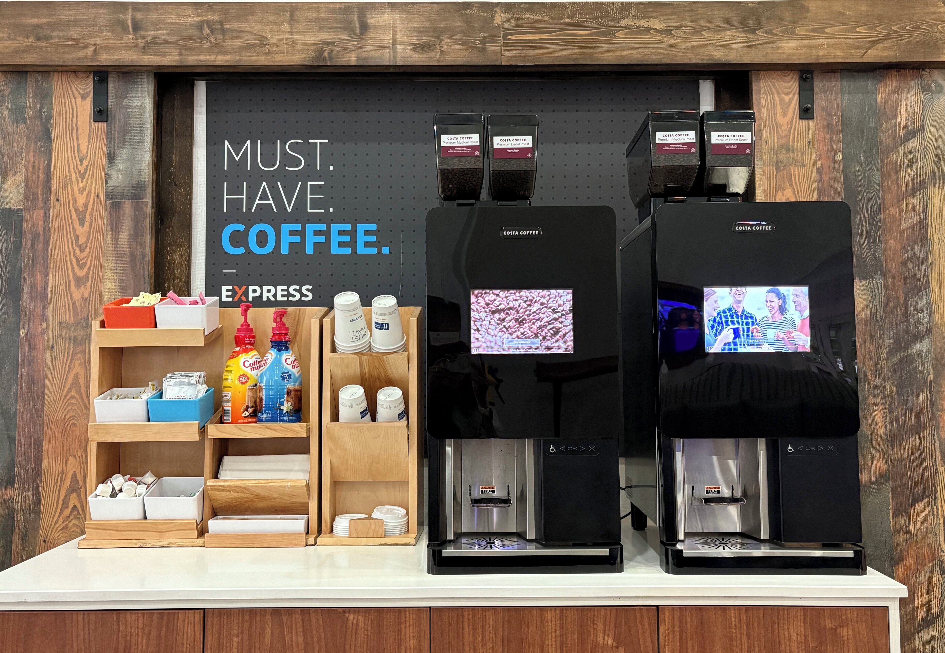 Un espace dédié au café, équipé de deux machines à expresso et d’un présentoir de capsules de café.