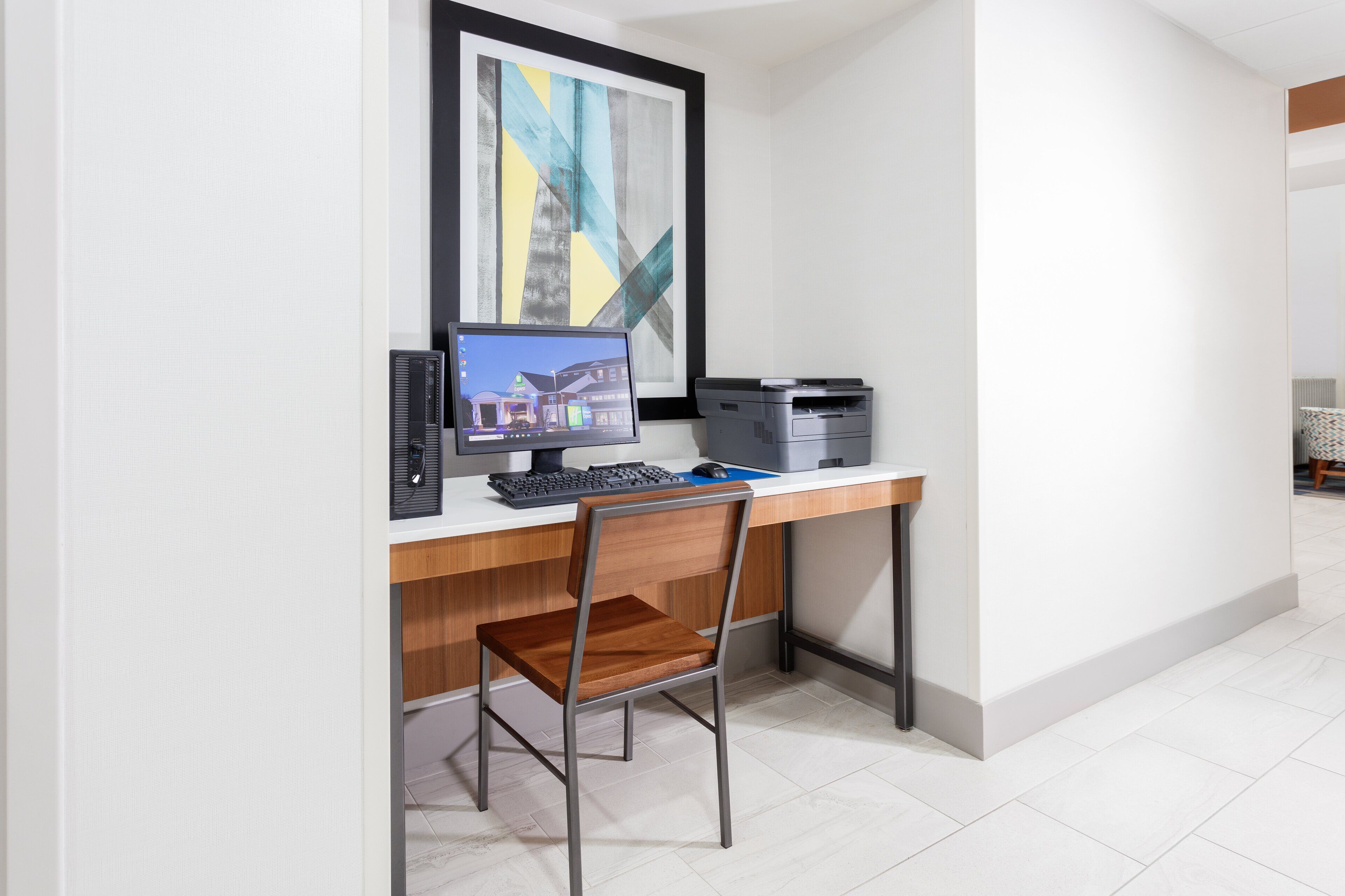 A modern office desk with a computer, keyboard, and mouse.