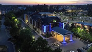 Un hotel dal design moderno, con un ampio parcheggio e un ingresso ben illuminato.
