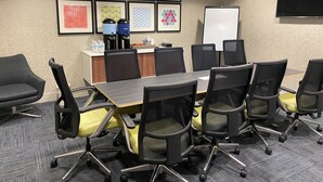 A conference room with a long table, black and yellow chairs, a whiteboard, and framed artwork on the wall. - Holiday Inn Express Hotel & Suites Independence-Kansas City by IHG (Independence)