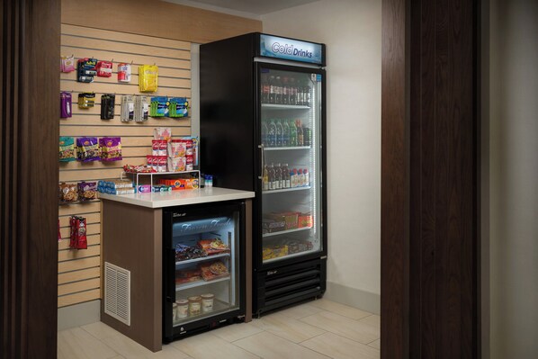 Una pequeña tienda de conveniencia con sección refrigerada para bebidas frías y alimentos congelados.