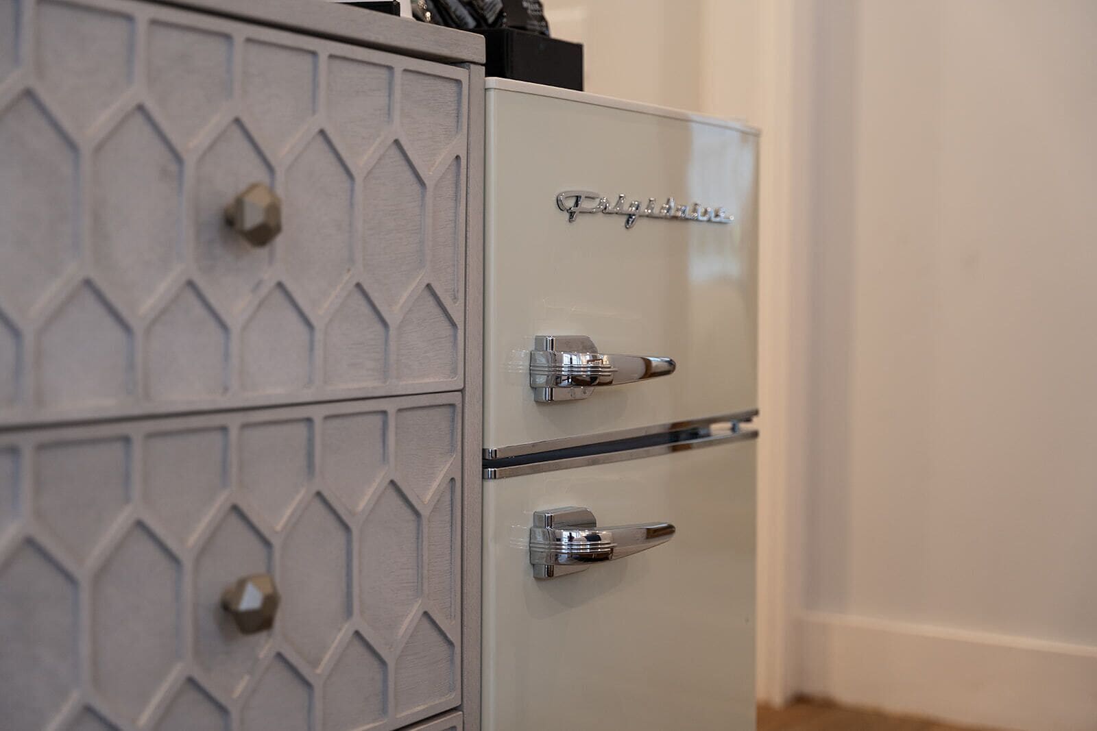 A metallic filing cabinet with a geometric pattern and three drawers.