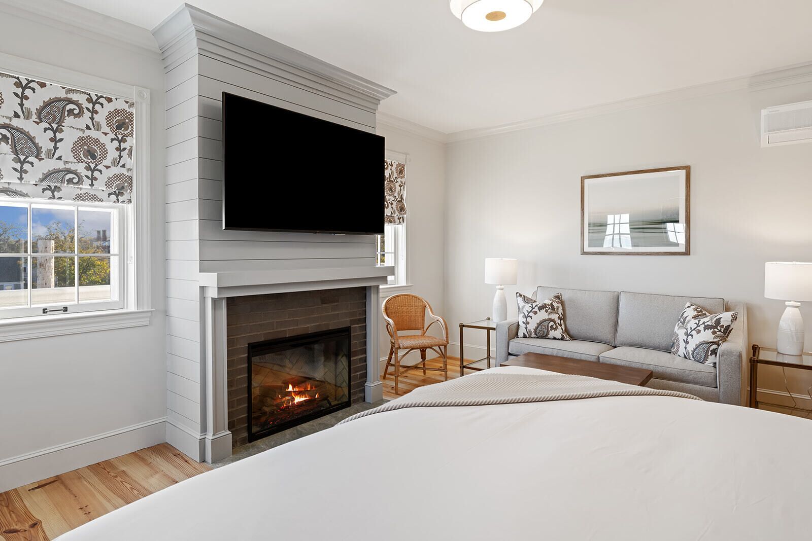 Une chambre à coucher moderne avec une cheminée, une télévision, un canapé et un lit.
