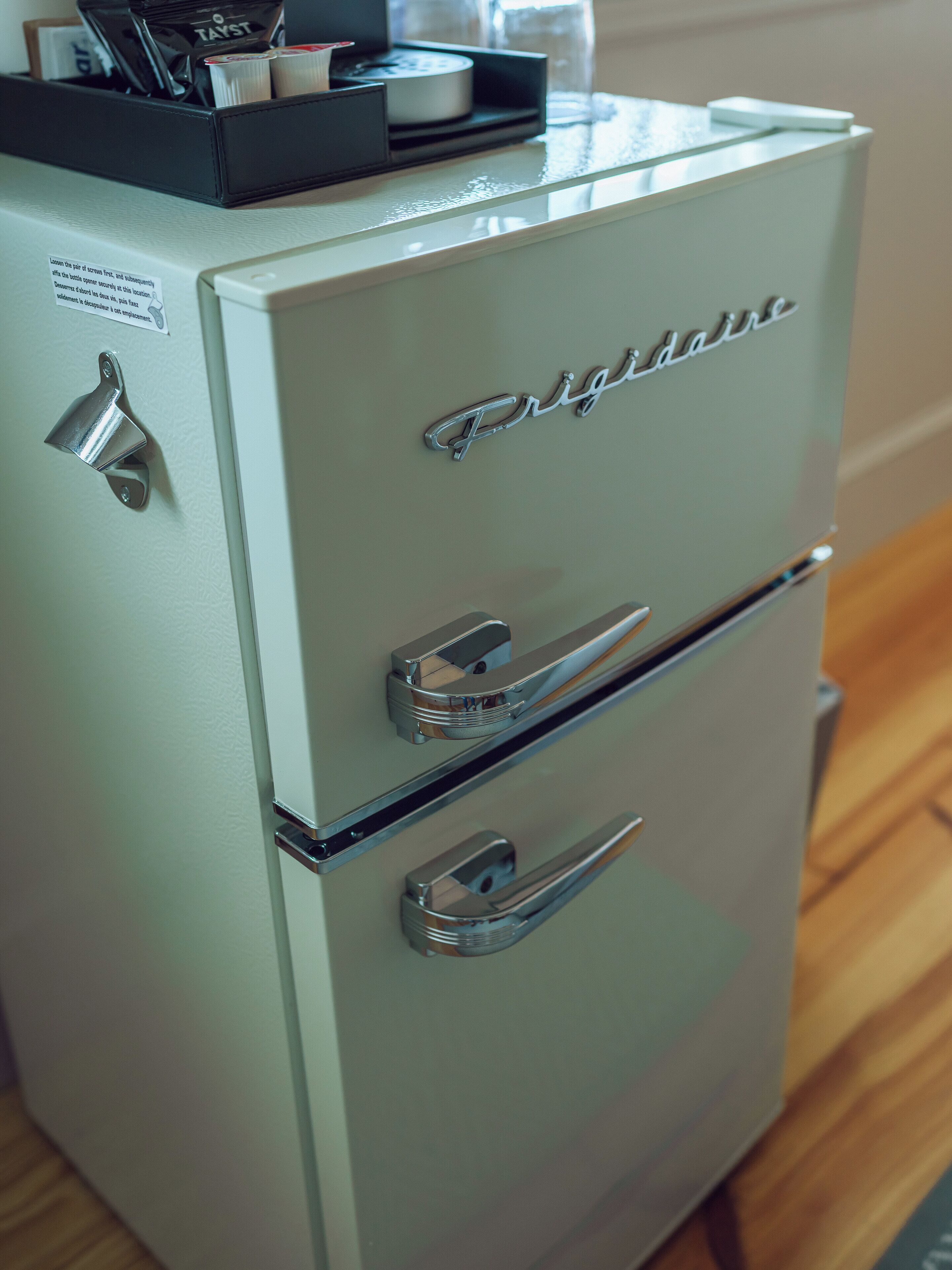 Un refrigerador Frigidaire antiguo con un mango cromado y un compartimento pequeño en la parte superior.