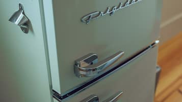Un refrigerador Frigidaire antiguo con un mango cromado y un compartimento pequeño en la parte superior.