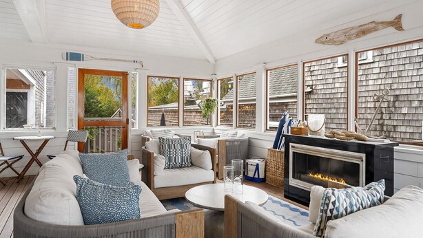 A cozy, well-lit room with a fireplace, comfortable seating, and large windows offering views of the outdoors. - Nantucket Resort Collection (Nantucket)