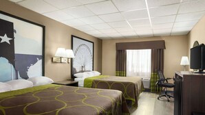 Hotelkamer met twee bedden, een bureau, een stoel, een televisie en een groot raam met gordijnen.