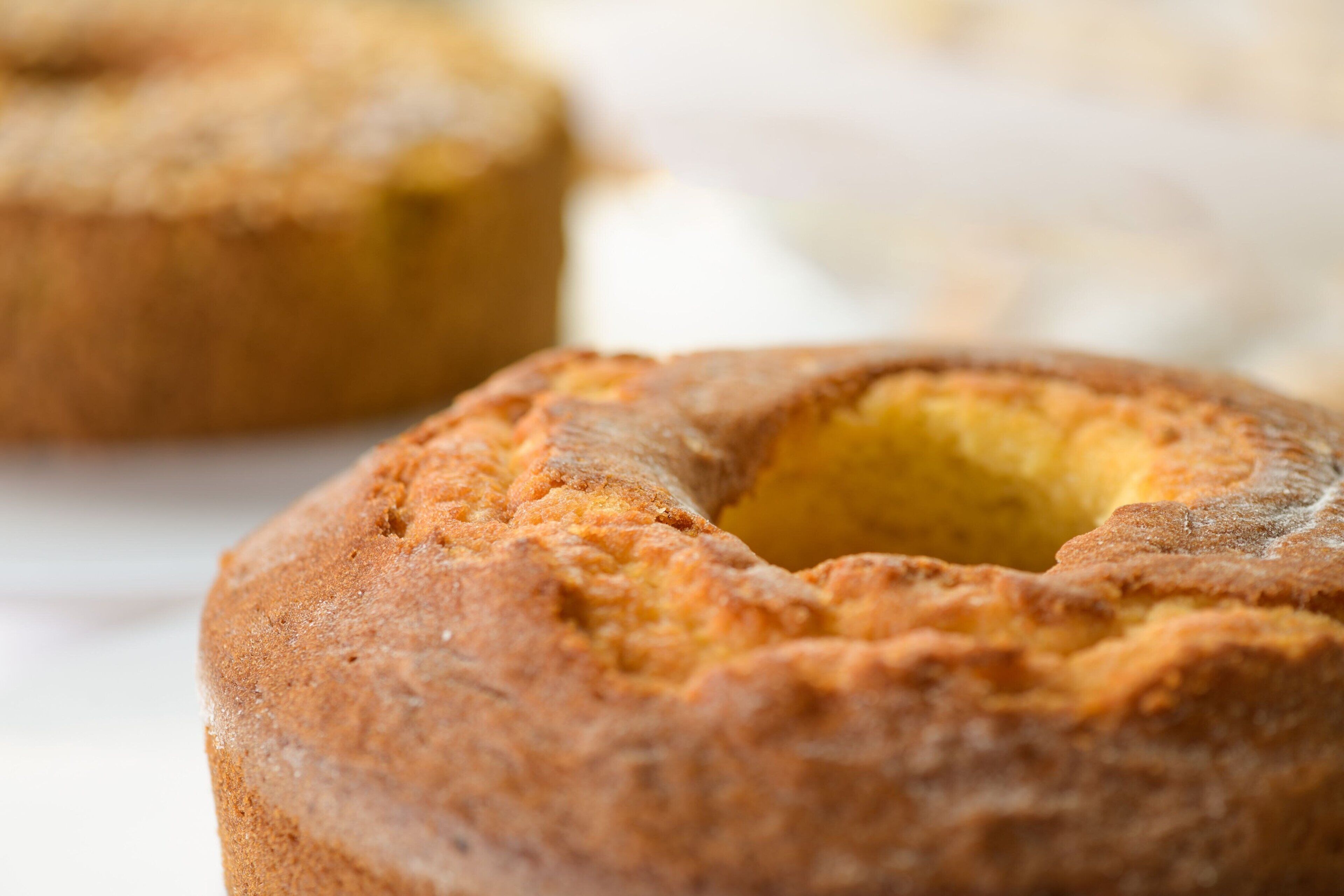 A close-up of a baked good with a golden-brown crust and a hollow center.