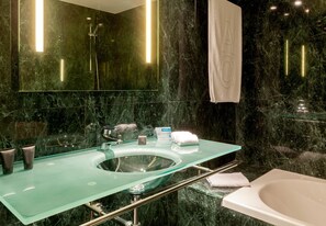 A modern bathroom with a glass sink, a bathtub, and a large mirror. - AC Hotel Córdoba by Marriott (Córdoba)