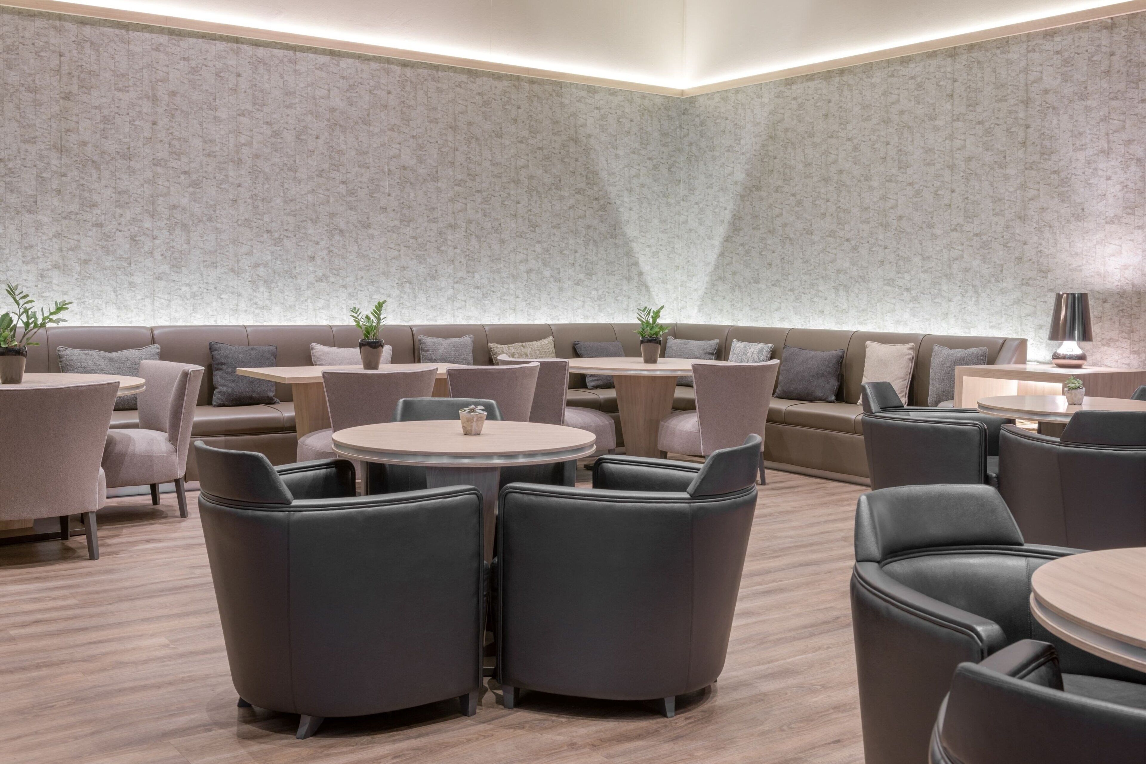 Ein moderner Lounge-Bereich mit Sofas, runden Tischen und Sesseln.