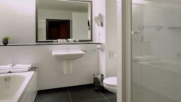 A modern bathroom with a glass shower enclosure, a white sink, and a toilet.
