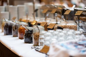 Ein Buffet mit verschiedenen Speisen in Gläsern und Behältern, jedes mit einer Karte beschriftet.