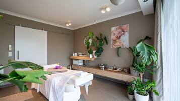 Experience serenity in this spa room with a massage table, plants, and calming ambiance.