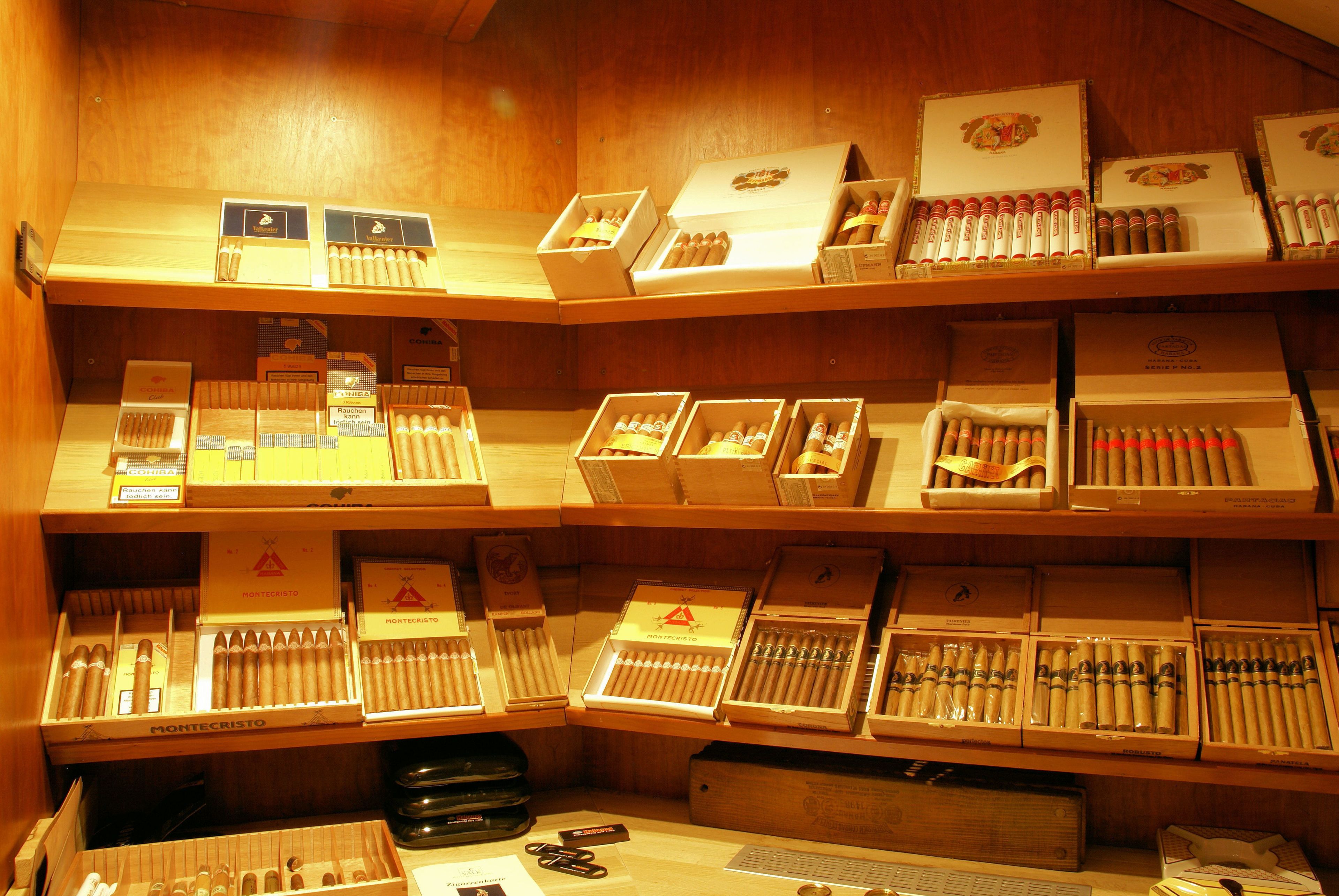 Una tienda de puros con varias estanterías que exhiben distintas marcas y tipos de cigarros.