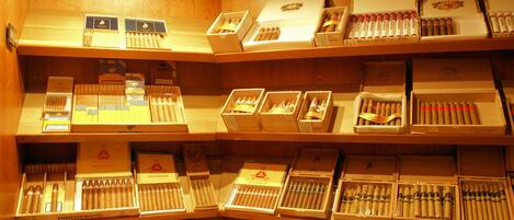 Una tienda de puros con varias estanterías que exhiben distintas marcas y tipos de cigarros.