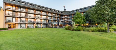 A multi-story hotel with a central courtyard, balconies, and a flag on top.