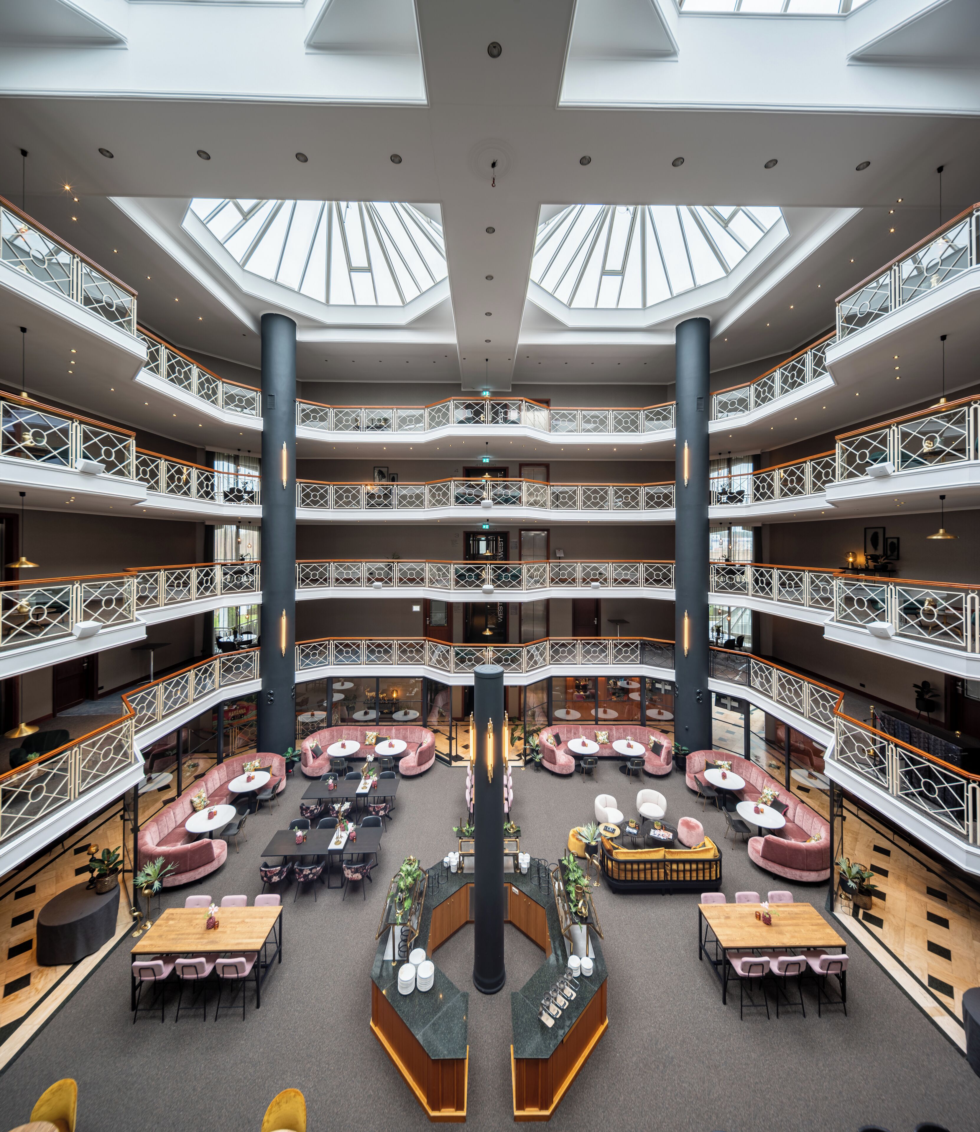 A multi-level atrium with a central column, multiple seating areas, and balconies.