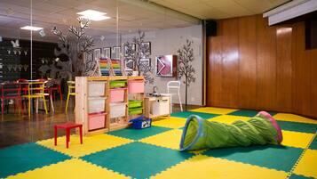 Children can play and explore in this vibrant room with a colorful floor, tunnel, and toys.