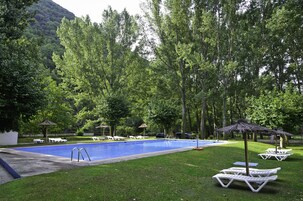 Una piscina cubierta, una piscina al aire libre de temporada, tumbonas