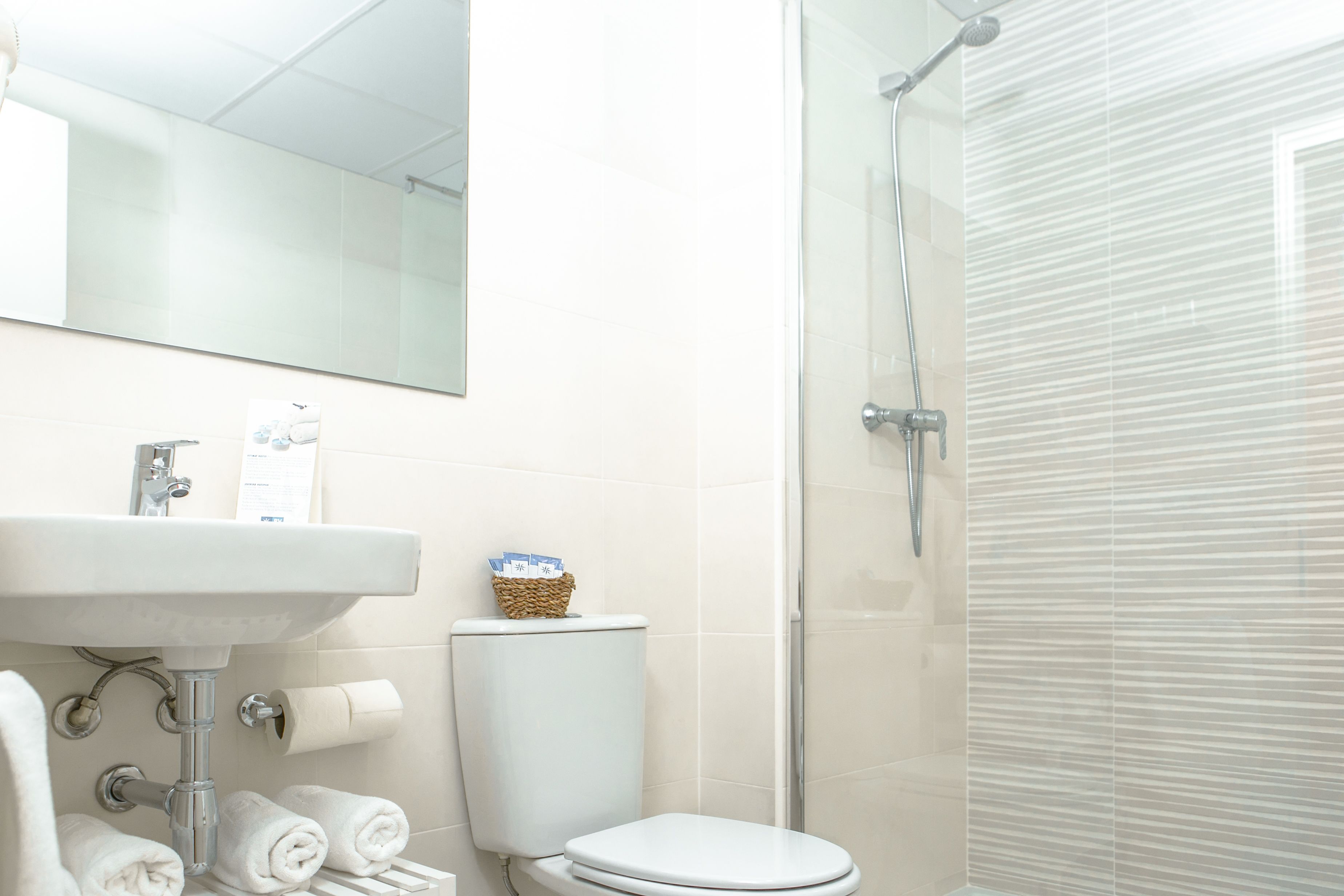 Un bagno con lavandino, wc e doccia.