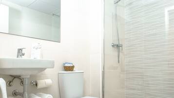 Un bagno con lavandino, wc e doccia.
