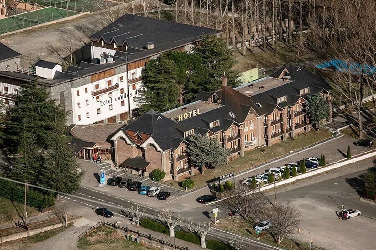 Un hotel con varias edificaciones, un estacionamiento y una carretera.
