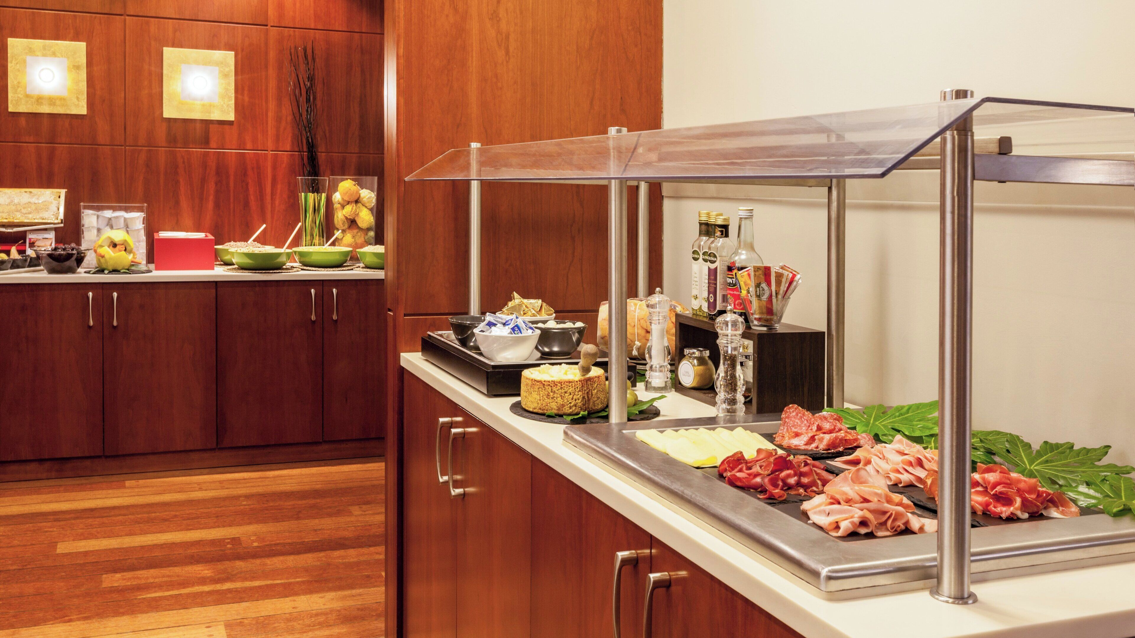 Een buffetopstelling met diverse gerechten, een drankstation en een decoratieve plant.