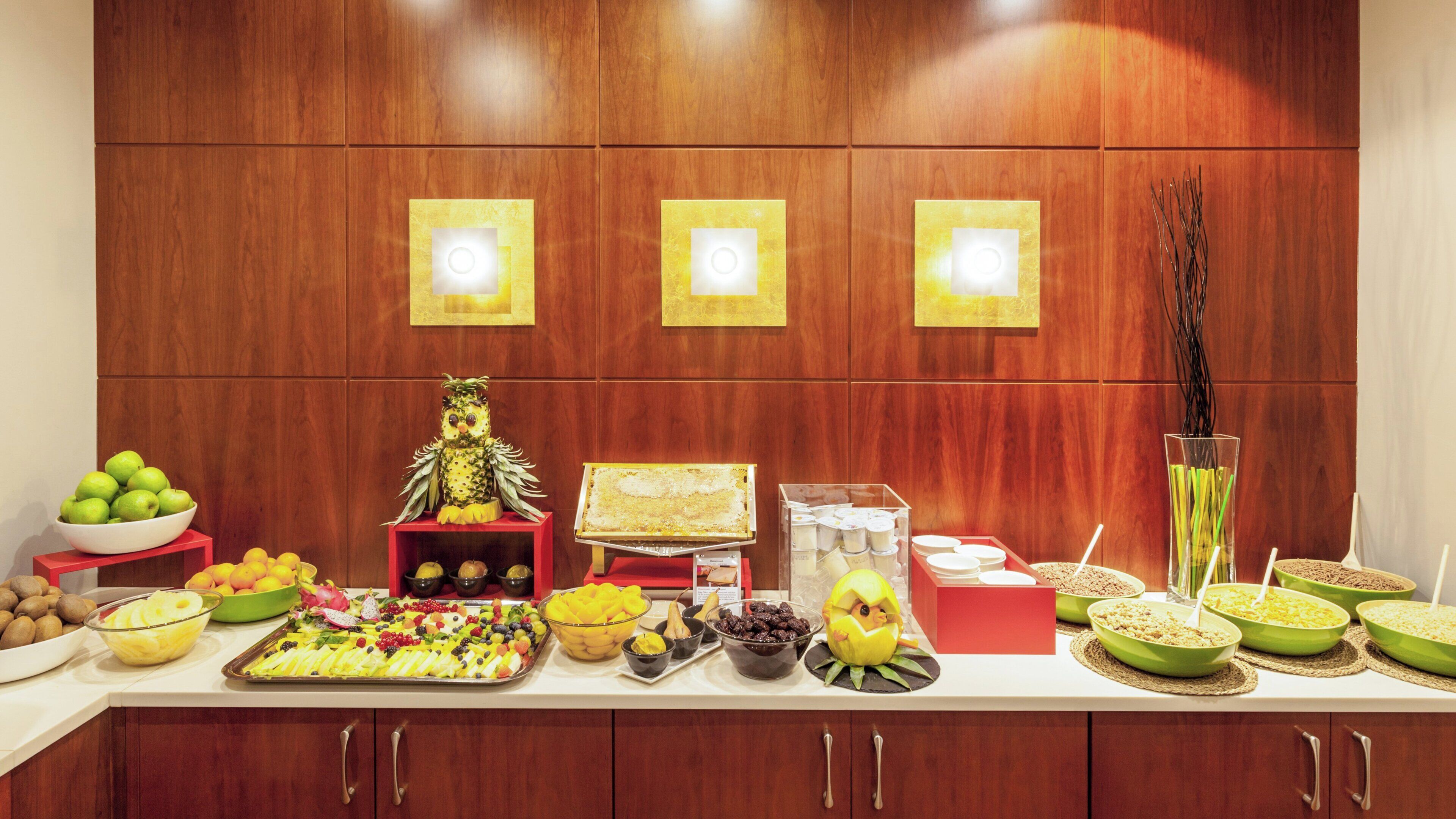 A buffet table with various food items and a decorative pineapple owl.