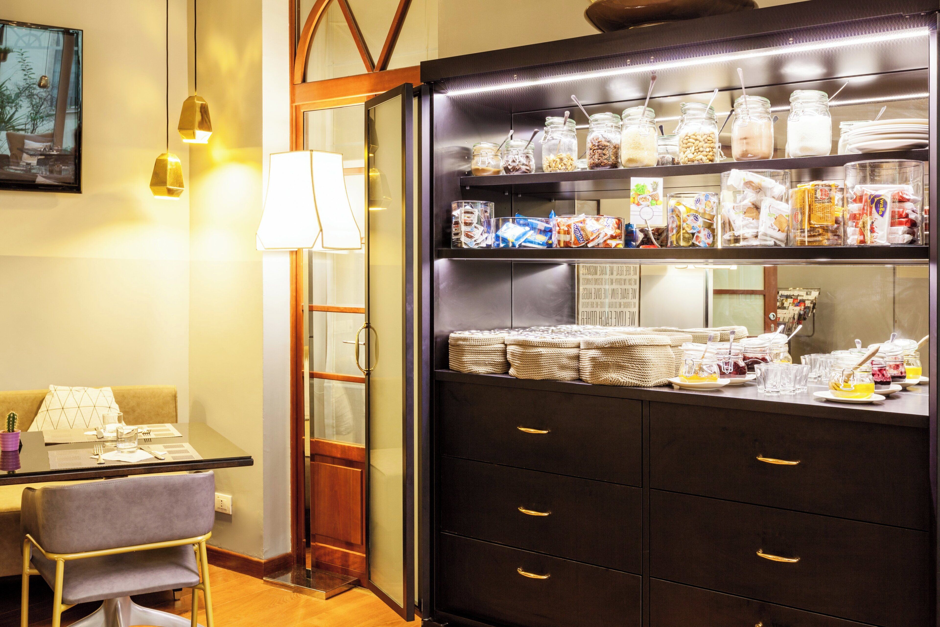 Een hotelkamer met een eethoek, een buffet met diverse gerechten en een zithoek.