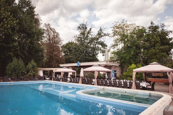 Una piscina al aire libre, tumbonas