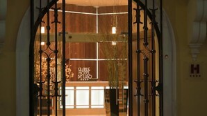 L’entrée du Grand Hôtel de Luso se distingue par une grande porte en arc de cercle et une enseigne indiquant le nom de l’hôtel.
