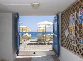 Na praia, espreguiçadeiras, guarda-sóis 